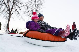 Kids tubing down hill in winter